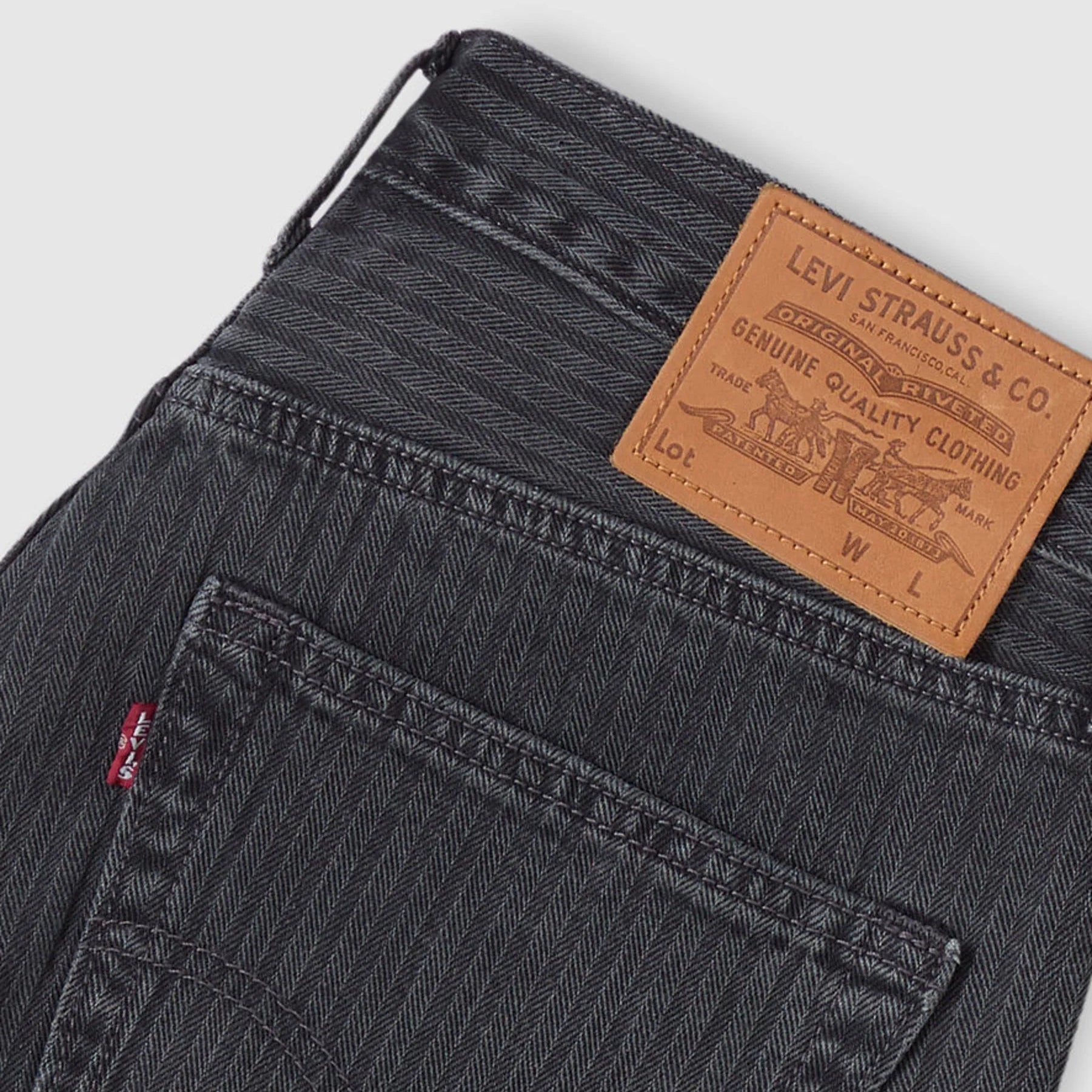 Close-up of Levi's jeans with a brand label on a light gray background