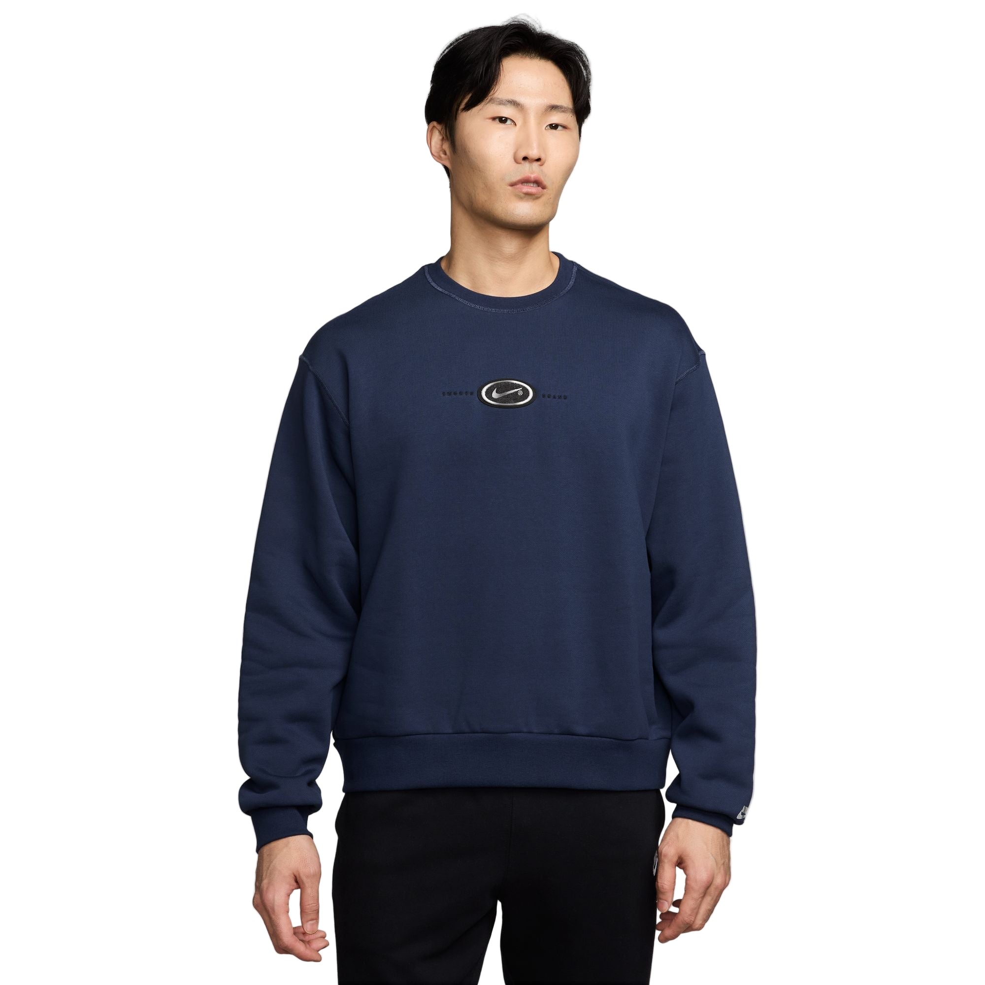 Man wearing a navy blue sweatshirt with a logo on a white background