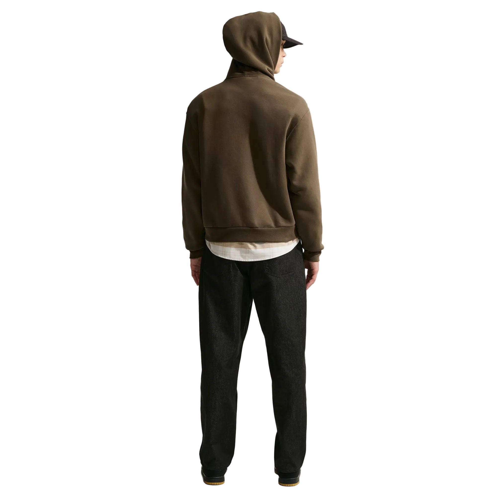 Person wearing a brown hoodie and dark pants on a white background