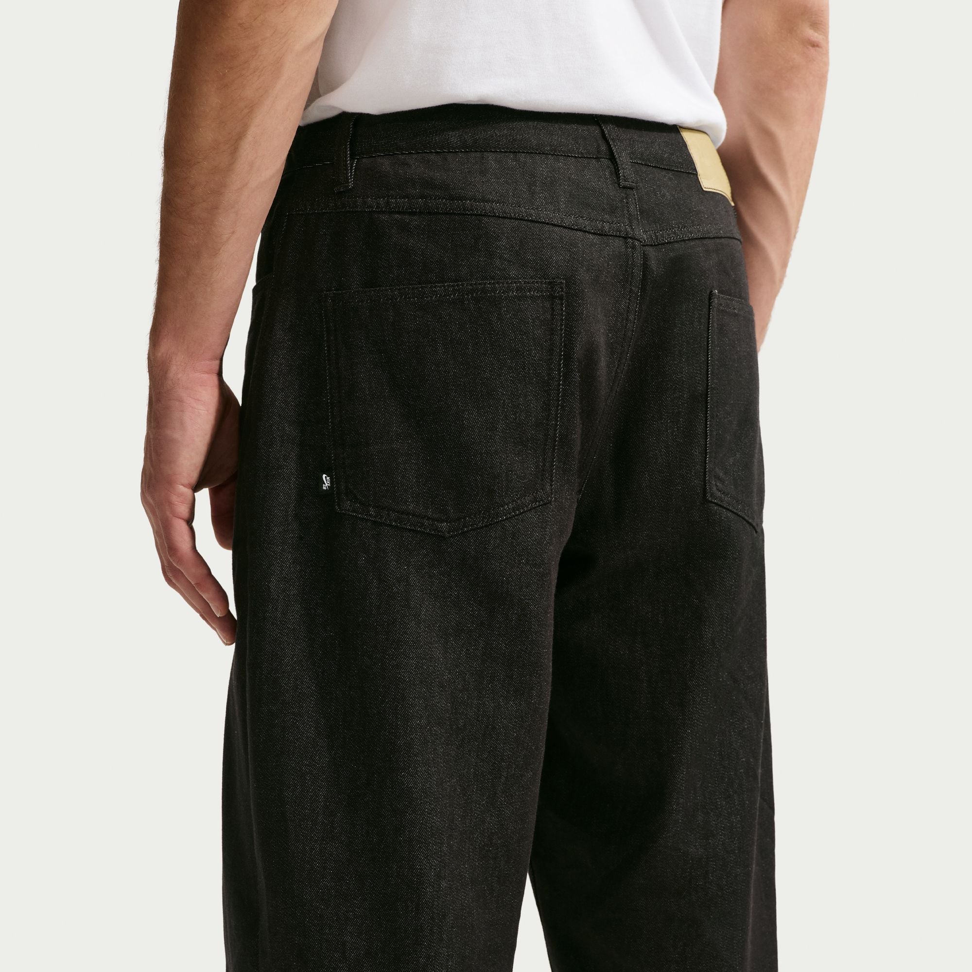 Person wearing black pants on a plain background