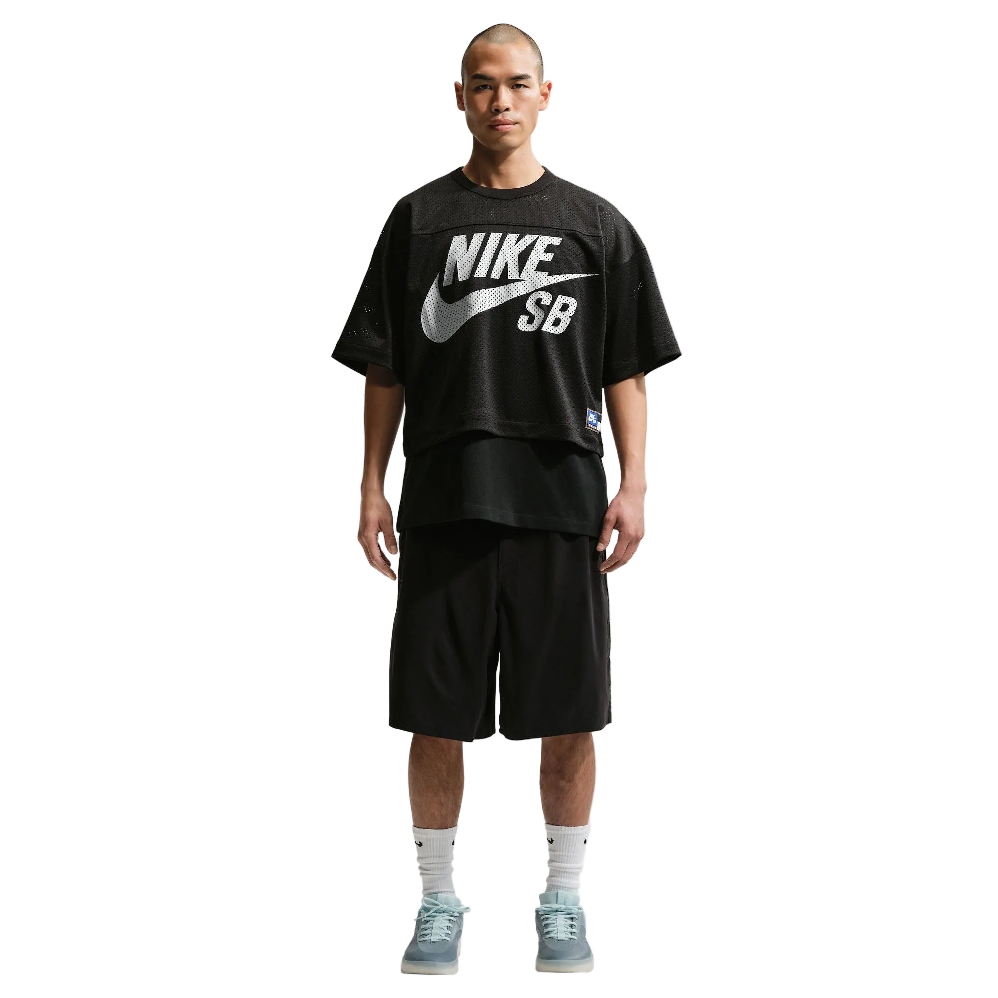 Person wearing a black Nike SB t-shirt and shorts on a white background