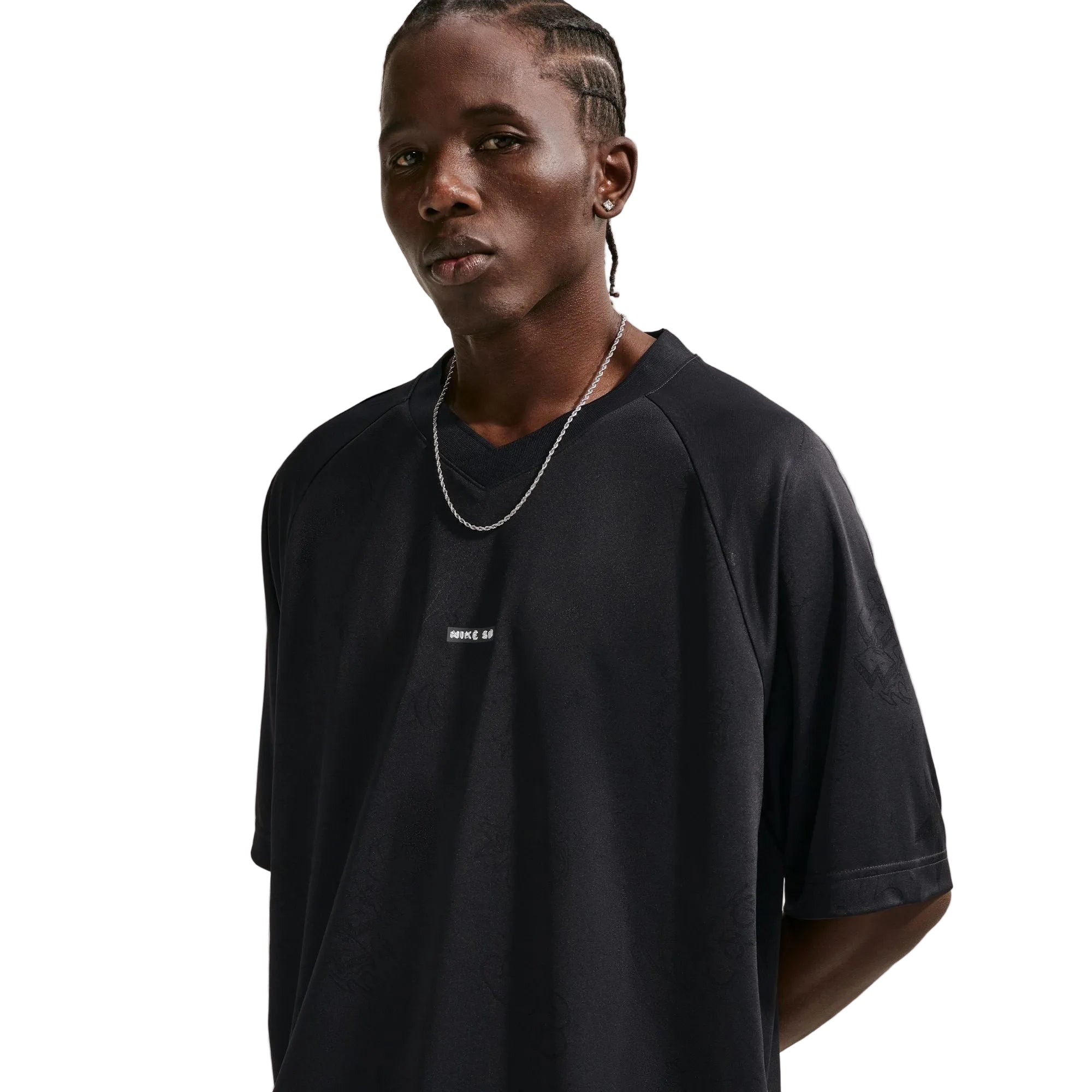 Person wearing a black t-shirt with a small white logo on a plain background