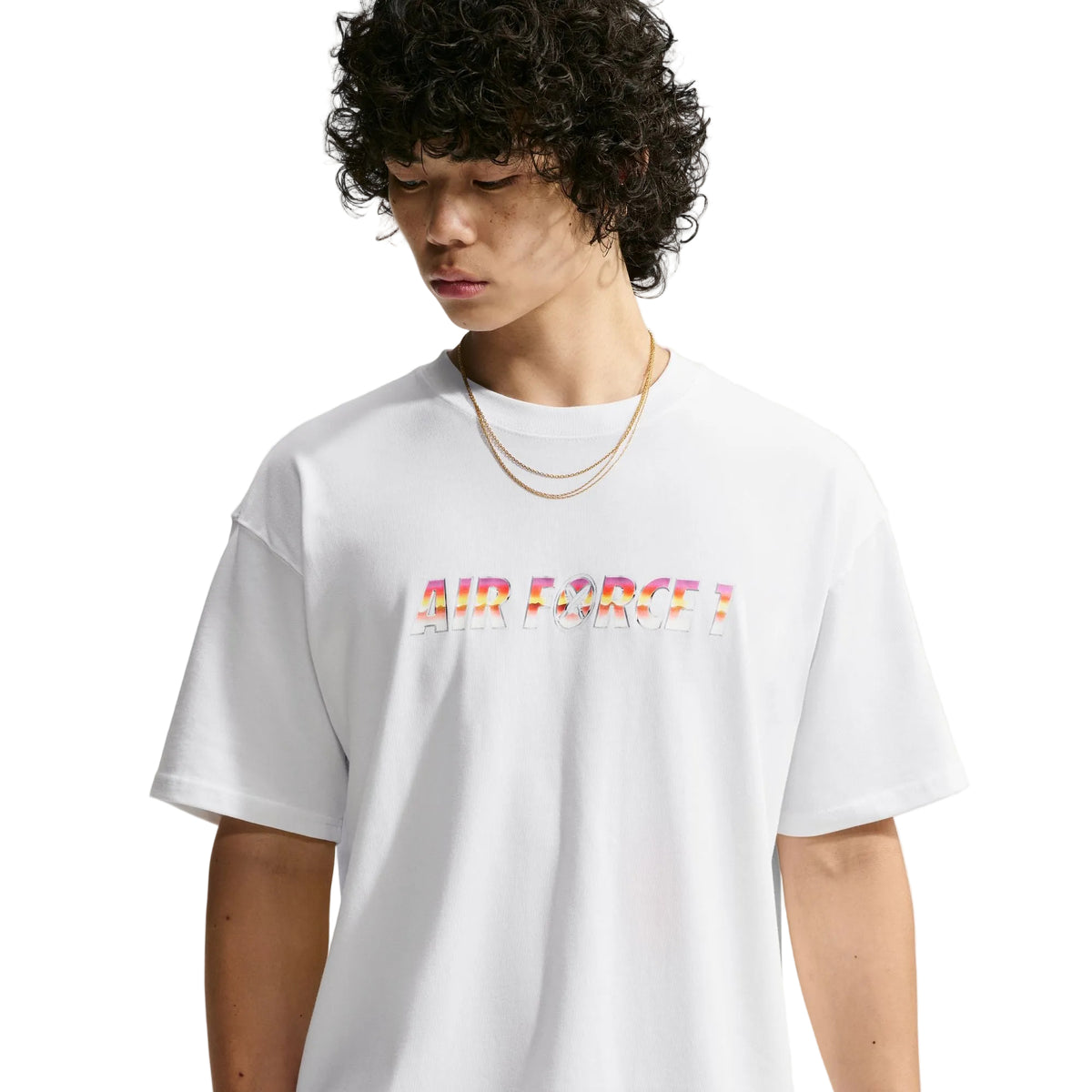 A model wearing a white oversized t-shirt with 'AIR FORCE' printed across the chest in a colorful, textured pattern, set against a plain light gray background.