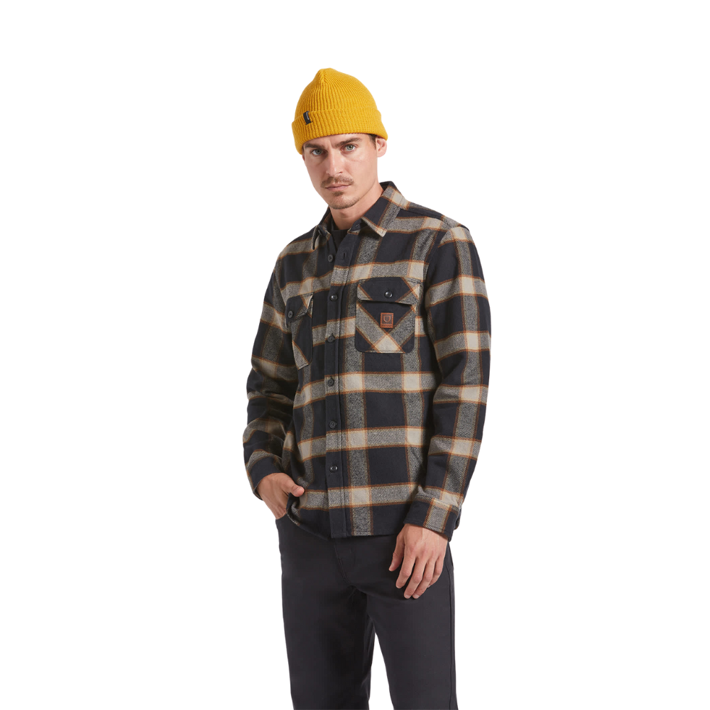 Person wearing a plaid shirt and yellow beanie on a white background