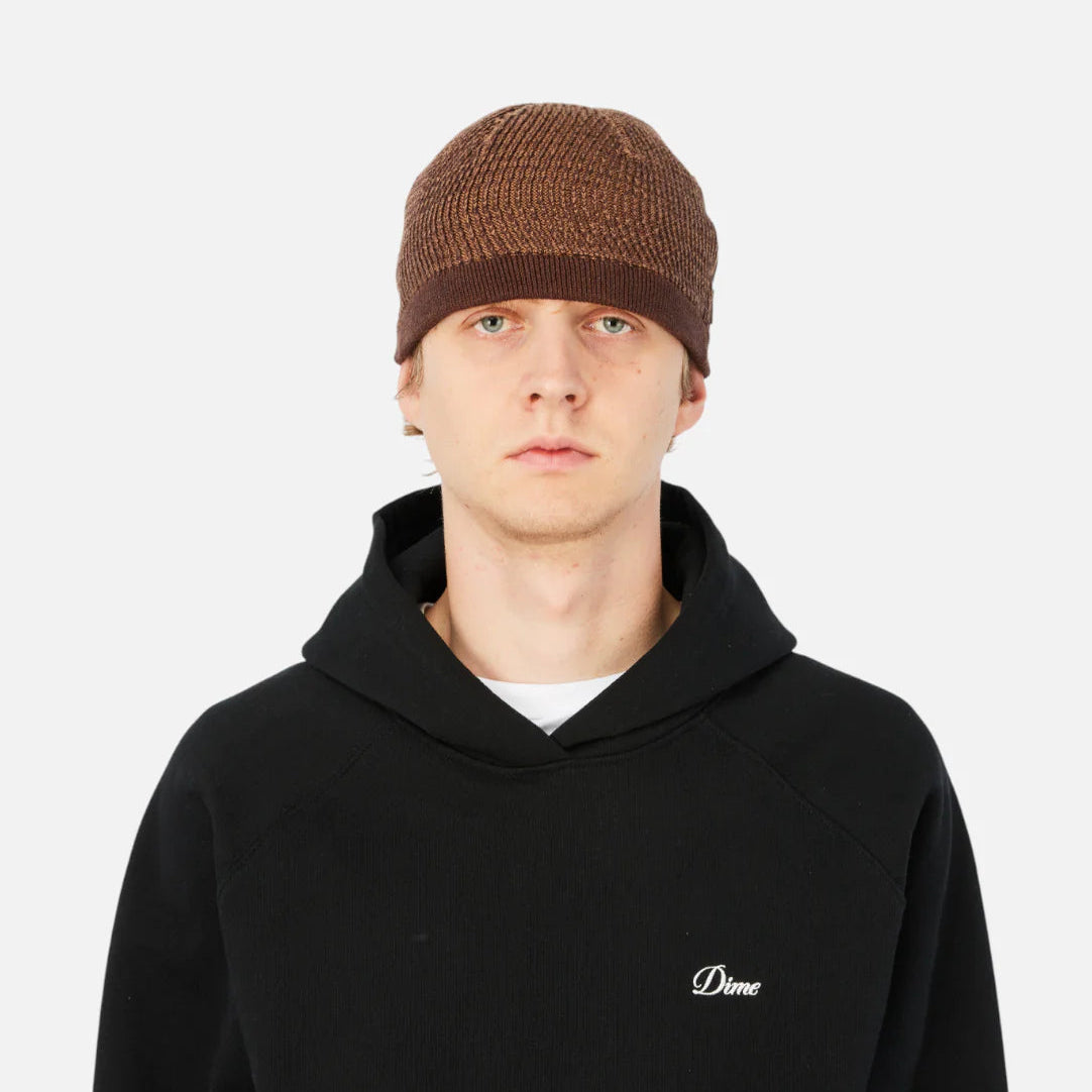 Person wearing a black hoodie with a small logo on a white background