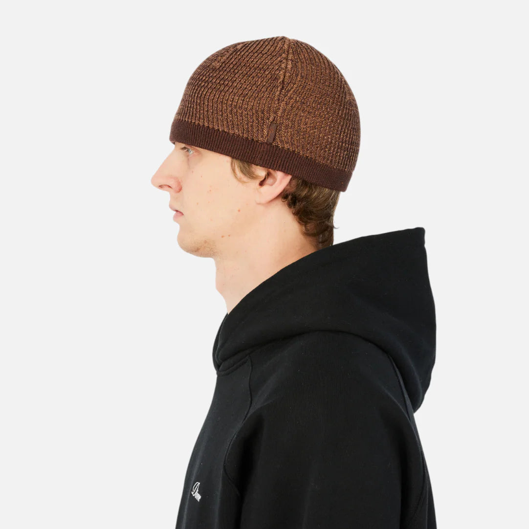 Person wearing a black hoodie and brown beanie on a white background