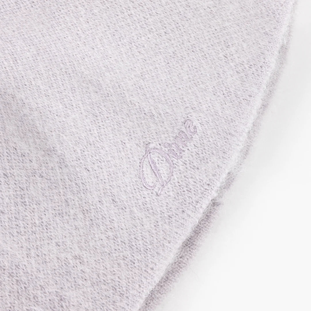 Close-up of a textured white fabric with a brand logo.