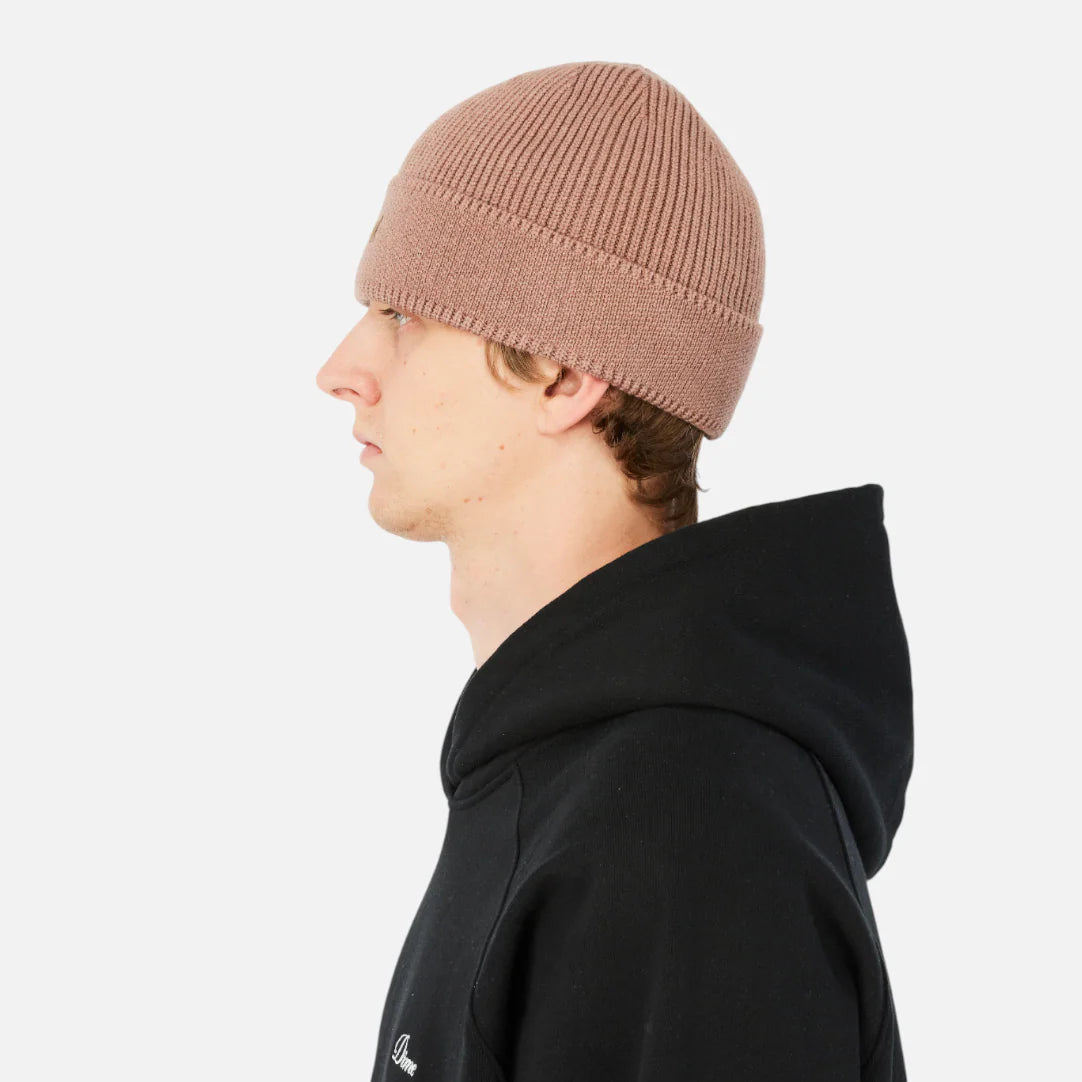 Person wearing a black hoodie and beige beanie on a white background