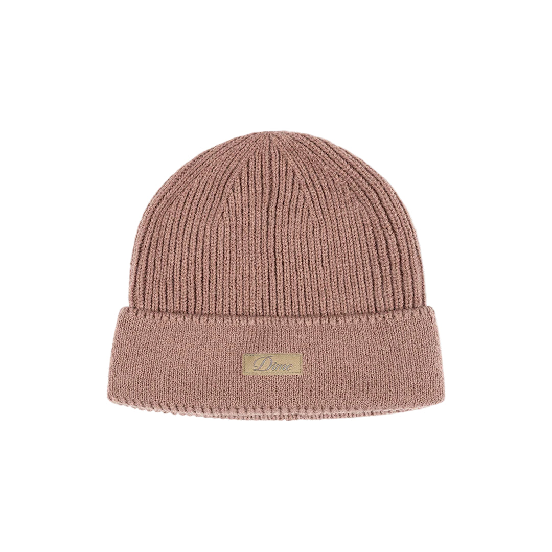 Pink knit beanie with a brand label on a light gray background