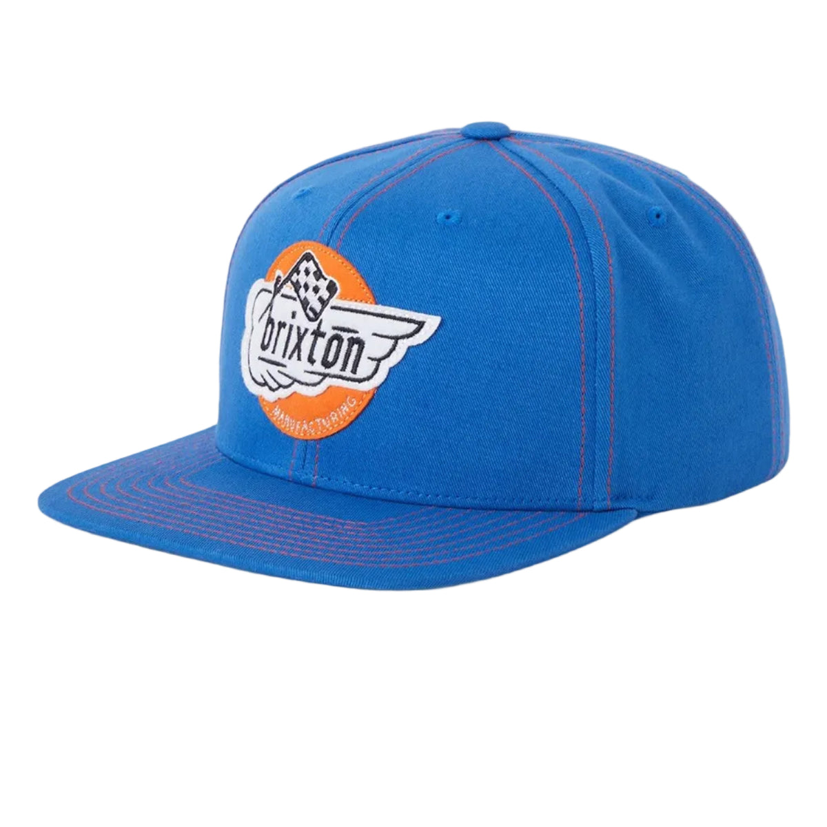 A blue snapback cap featuring an embroidered circular patch on the front with the word 'BRIXTON' and a winged logo, set against a light gray background.