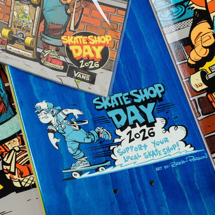 Blue skateboard deck with 'Skate Shop Day 2016' graphic and Vans branding.