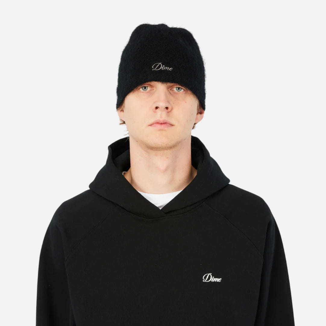 Person wearing a black hoodie and beanie with 'Dime' logo on a white background
