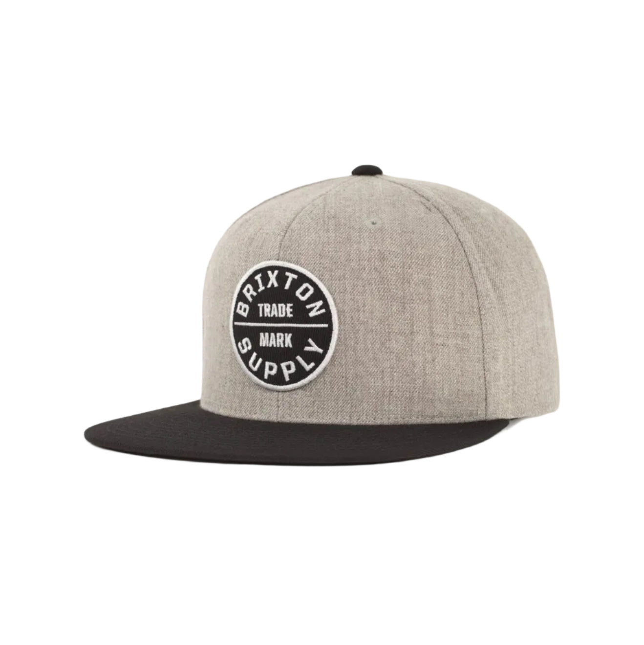 A heather gray snapback cap with a black flat brim and a circular black and white Brixton Supply logo patch on the front, shown against a light gray background.